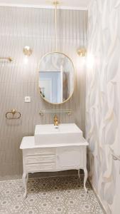 ein weißes Badezimmer mit einem Waschbecken und einem Spiegel in der Unterkunft Ferienwohnung 24 am Saseler Markt hochwertig renoviert in Hamburg