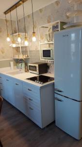 eine Küche mit einem weißen Kühlschrank und einer Spüle in der Unterkunft Ferienwohnung 24 am Saseler Markt hochwertig renoviert in Hamburg