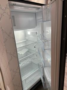 un réfrigérateur vide avec une porte ouverte avec une porte ouverte dans l'établissement Ferienwohnung Watzmann-Stüberl 51 gehobene Ausstattung, à Hambourg