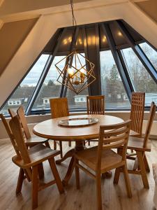 a dining room table and chairs with a large window at Ferienwohnung Gipfelglück 50b für Familien in Hamburg