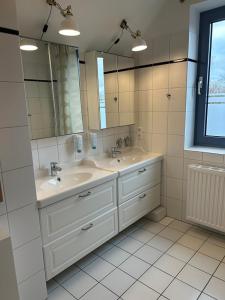 a bathroom with two sinks and a large mirror at Ferienwohnung Gipfelglück 50b für Familien in Hamburg