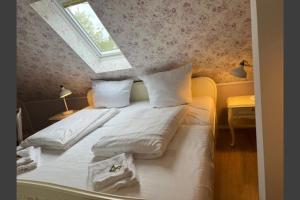 um quarto com uma cama branca e uma clarabóia em Studio-Apartment 29 beim Saseler Markt frisch renoviert em Hamburgo