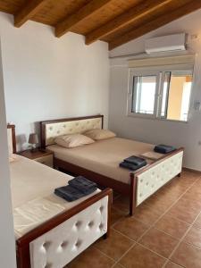 a bedroom with two beds and a window at Guesthouse Mateo in Dhërmi