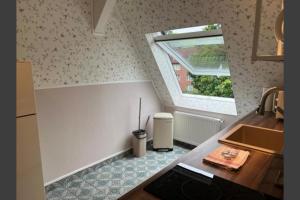 uma pequena cozinha com um lavatório e uma janela em Studio-Apartment 29 beim Saseler Markt frisch renoviert em Hamburgo