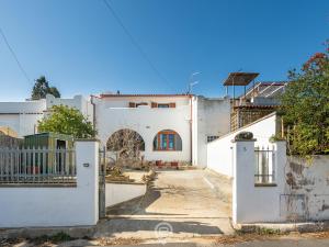 ein weißes Haus mit einem Tor und einem Zaun in der Unterkunft Angelica's beachside apartment in Porto Columbu - Perdʼe Sali