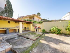 una casa con una pared amarilla y un patio en Angelica's beachside apartment, en Porto Columbu - Perdʼe Sali