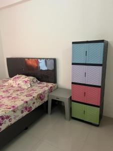 a bedroom with a bed and a table and a dresser at Ita Room Apartement Serpong Green View in Ciater-hilir