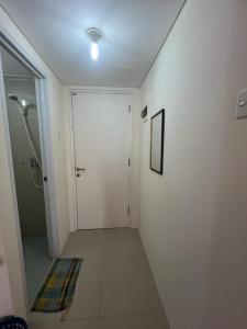 a bathroom with a shower and a white door at Ita Room Apartement Serpong Green View in Ciater-hilir