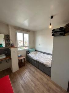 een kleine slaapkamer met een bed en een raam bij Appartement familial (idéal JO 2024) in Montreuil