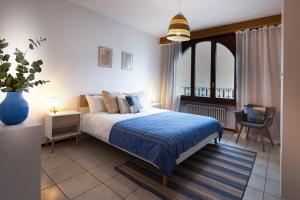 een slaapkamer met een bed met een blauw dekbed bij 4.5 locali magnifica vista lago e parking pubblico in Mendrisio