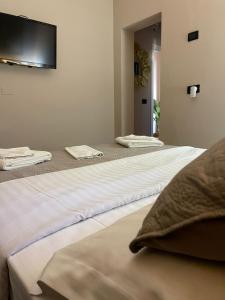 three beds in a room with towels on them at MARION HOTEL in Tirana