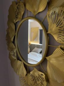a mirror with a gold leaf design on a wall at MARION HOTEL in Tirana