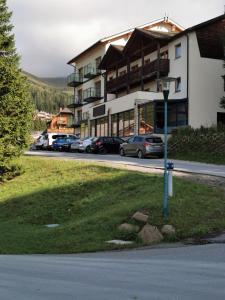 ein Parkplatz mit Autos vor einem Gebäude in der Unterkunft Alpengasthof Tanzstatt in Lachtal