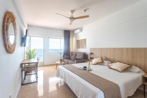 a bedroom with a large bed and a couch at Apartamentos Mirador in Benidorm