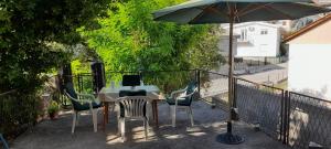 d'une table, de chaises et d'un parasol sur le balcon. dans l'établissement Guest house Ruzica, à Sutomore