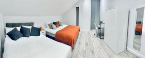 - une chambre avec 2 lits et une couverture orange dans l'établissement Luxury Town Centre House, Faversham, à Faversham