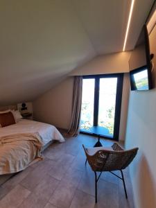 Castrelo de Miño的住宿－Casa do Barqueiro CAIÑO，一间卧室配有一张床、一把椅子和窗户。