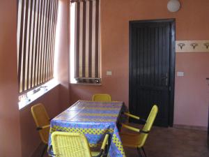 Habitación con mesa, sillas y puerta en Borgo Spiaggia Isola Rossa, en Isola Rossa