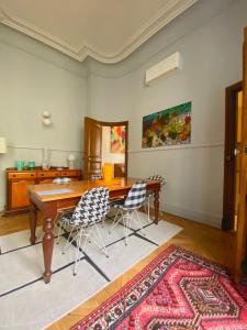 CARCASSONNE HISTORIC DUPLEX 4 star air conditioned APARTEMENT d`ÉGLANTINE في قرقشونة: غرفة طعام مع طاولة وكراسي خشبية