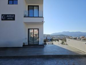 a white building with a door and a balcony at Adele Hotel Ksamil in Ksamil