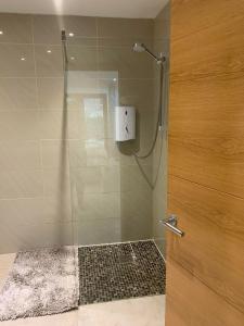 a shower with a glass door in a bathroom at Spacious Self Contained 1 Bedroom Flat Colwinston 