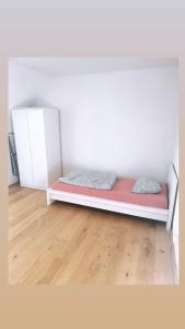 Bett in einem weißen Zimmer mit Holzboden in der Unterkunft Montel PARK - Stockholm in Linz