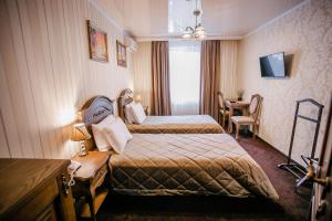 a hotel room with two beds and a table at Aristokrat in Vinnytsya