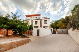 uma grande casa branca com uma entrada em Villarrobles de Altamira em Cortijos Nuevos