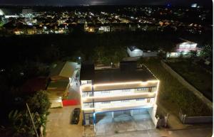 a white building at night with a city at Caishen Apartelle 301 in Silang