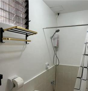 a bathroom with a shower with a toilet and a sink at Caishen Apartelle 301 in Silang