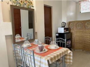 SilangにあるCaishen Apartelle 301のテーブル、テーブルクロス、椅子付きのキッチンが備わります。