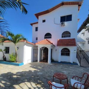 a large white house with a courtyard at Casa angelina in Sosúa