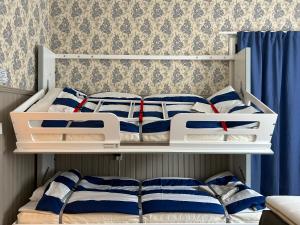EnångerにあるEnångers Bed and Breakfastの白い二段ベッド2組(青と白の枕付)