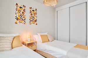 a bedroom with two beds and a picture on the wall at CASA LA BOTAVARA - Pool & Beach in Abades