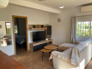a living room with a couch and a tv at Villa Vanessa in Alhaurín de la Torre
