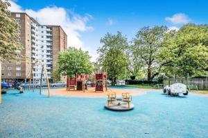a park with a playground with two swings at Central Apartment in Bedford