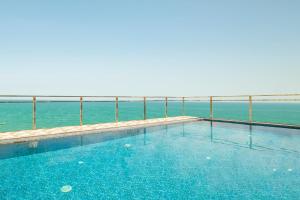 a swimming pool with the ocean in the background at Palazzo Boutique Hotel in Danang