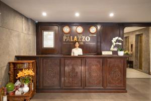 a man standing behind a counter in a lobby at Palazzo Boutique Hotel in Danang