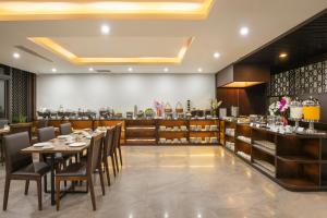 a restaurant with tables and chairs and a bar at Palazzo Boutique Hotel in Danang