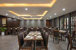 a restaurant with wooden walls and tables and chairs at Palazzo Boutique Hotel in Danang