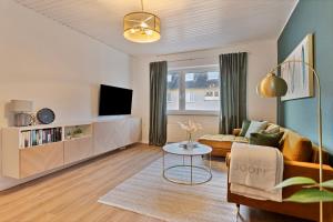 een woonkamer met een bank en een tafel bij Villa trifft Zeche by Cordis Sky für bis zu 7 Personen 5 Minuten zur Messe Essen und zum Hauptbahnhof Essen in Essen