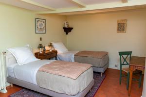 - une chambre avec 2 lits, une table et un bureau dans l'établissement Domaine de Montclair, à Pommiers
