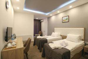 a hotel room with two beds and a table at Baku ZamZam Hotel in Baku