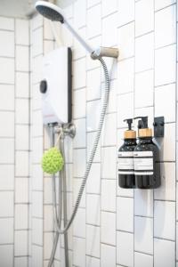 a shower in a bathroom with white tiles at RALPH Bangkok in Bangkok