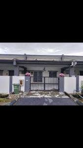 a white house with a gate and a fence at Rabb Homestay Samarahan in Kampong Setigang +5 photos