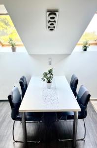 a meeting room with a white table and chairs at Chill apartman in Budakalász