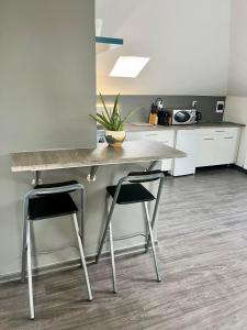 cocina con mesa y 2 sillas en Chill apartman, en Budakalász