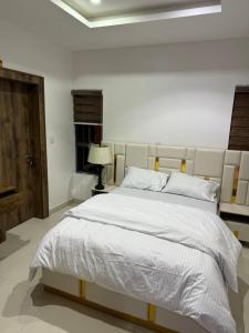 a white bedroom with a large white bed in it at SAMBEST Home in Lagos
