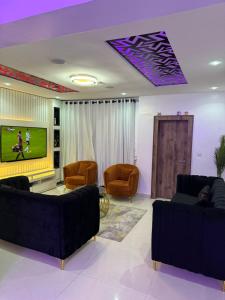 a living room with couches and a flat screen tv at SAMBEST Home in Lagos