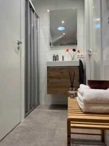 a bathroom with a sink and a shower and a bench at @TheLodge 